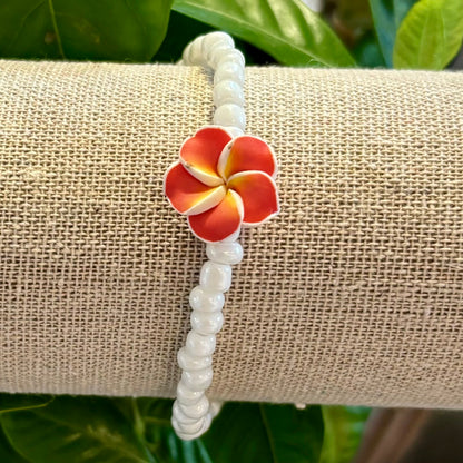 Armbånd med hvide perler og Hawaiiblomst