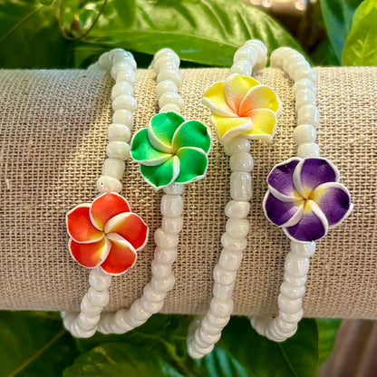 Armbånd med hvide perler og Hawaiiblomst